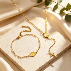Detailed view of the 18K gold plated stainless steel cross necklace and bracelet set.