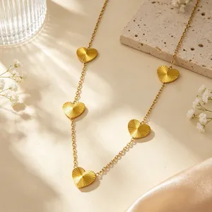Dettaglio squisito della collana con ciondoli a cuore multipli in acciaio inox dorato.