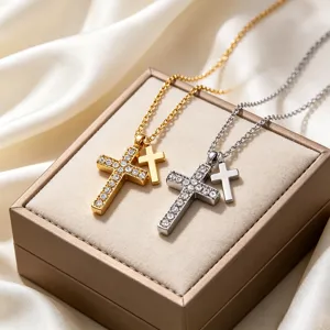 Detailed close-up of double cross pendant necklaces with sparkling rhinestones on jewelry box.