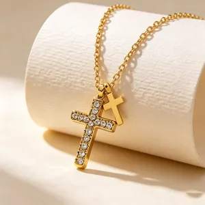 Detailed shot of double cross pendant necklace featuring sparkling rhinestones on gold chain.