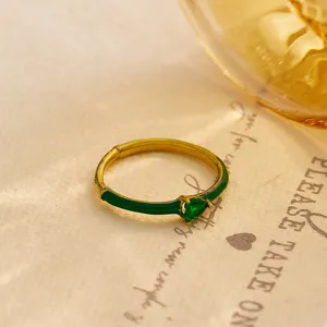 Close-up detail of green heart zirconia ring with enamel accent and gold band finish.