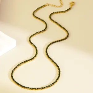 Detail view of gold-tone tennis necklace featuring sparkling green crystal stones and clasp.