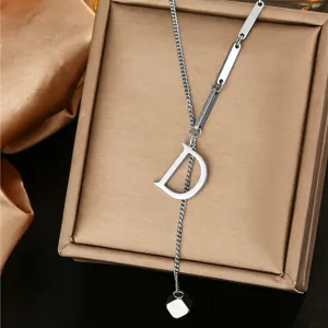Detail shot of a stylish stainless steel letter D pendant necklace on a luxury box.