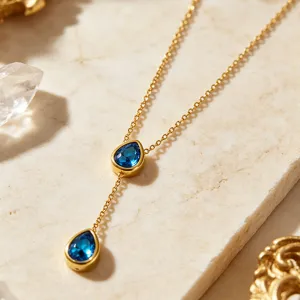 Elegant 18K gold plated stainless steel Y necklace featuring blue teardrop crystal pendants.