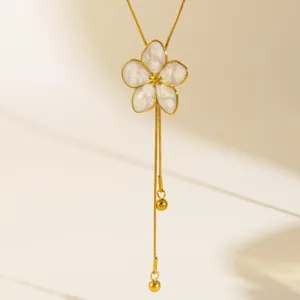 Detailed close up of gold plated stainless steel flower pendant necklace with tassel
