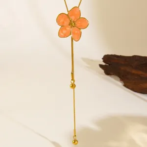 Close-up detail of the elegant 18K gold plated stainless steel peach enamel flower lariat necklace.