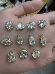 Primo piano dettagliato di vari ciondoli zirconi geometrici dorati accessori gioielli DIY