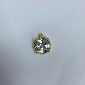 Primo piano dettaglio di un ciondolo quadrato in zircone cubico placcato oro componente fai da te.