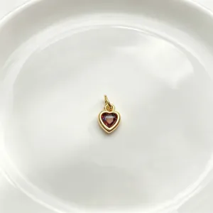 Detailansicht eines schönen herzförmigen farbigen Zirkonia-Anhängers mit Goldbeschichtung.