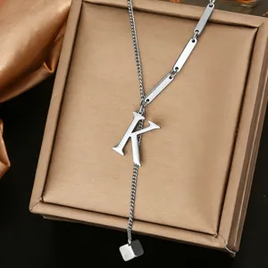 Close-up detail of stainless steel letter K Y-necklace pendant, elegant metallic texture.