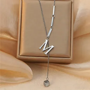 Stainless steel letter M pendant necklace with cube charm, elegant clavicle chain jewelry detail.