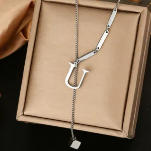 Close up of a silver stainless steel letter U pendant lariat necklace with bar links and cube.