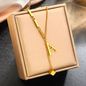 Gros plan du collier lettre A en acier titane doré, accessoire de présentation de bijoux.