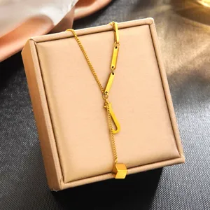 Collier pendentif lettre J en acier inoxydable doré, vue détaillée sur une boîte à bijoux élégante.