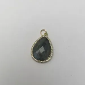 Tropfenförmiger Naturstein-Anhänger mit micro-gefassten Zirkonia Steinen in Goldfassung.