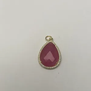 Detailaufnahme tropfenförmiger Naturstein Anhänger mit Zirkonia-Rand in glänzendem Gold-Look.
