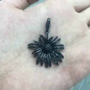 Nahaufnahme Detail eines stilvollen gunmetal schwarzen Pavé Kristall Blumenanhängers.