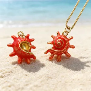 Detailed close-up of red enamel sea conch pendants on sandy beach background, ideal for DIY jewelry.
