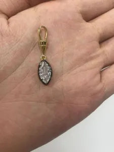 Primo piano dell'accessorio pendente in strass marquise con dettagli metallici e di pietra.