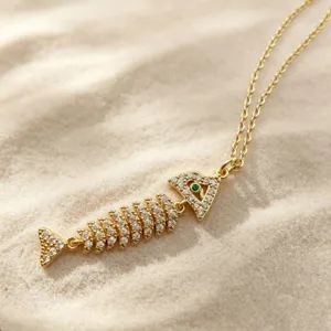 Gold fish skeleton necklace pendant detail, micro-paved zirconia, ocean series accessory.