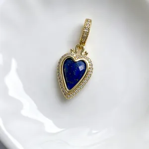 Detailansicht eines vintage herzförmigen Lapislazuli Anhängers mit goldener Pave Fassung.