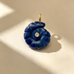 Vue détaillée du superbe pendentif exquis en pierre précieuse sculptée en forme de coquillage.