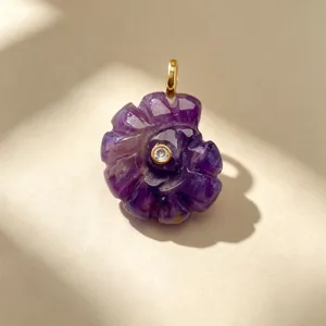Gros plan détaillé du pendentif coquillage en améthyste sculptée avec attache dorée.