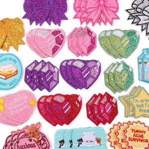 Close up of colorful glitter embroidered patches, cute hearts, bows and gems for DIY decor.