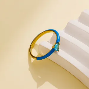 Detailed view of a chic 18K gold plated stainless steel ring with bright blue enamel and blue zircon.