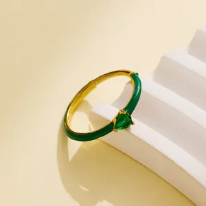 Close up detail of green heart cubic zirconia gold ring with elegant enamel coating style.