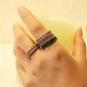 Close-up detail of stackable multi-color zirconia eternity rings worn on hand model.