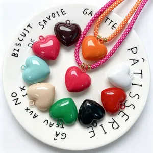 Detailed shot of colorful enamel heart pendants and DIY braided necklaces accessories.