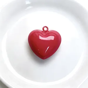 Detailed view of a glossy red enamel heart charm pendant for DIY necklace jewelry crafting.