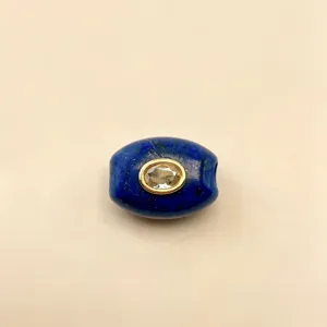Nahaufnahme einer blauen Lapislazuli Perle mit gefasstem Zirkon Anhänger für DIY Schmuck.