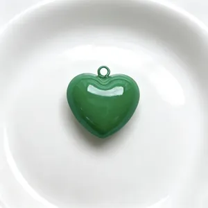 Green enamel heart pendant detail shot, glossy finish charm for DIY handmade jewelry crafting.