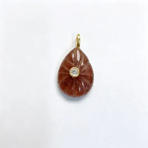Closeup detail view of carved teardrop gemstone pendant featuring a center set brilliant zircon.