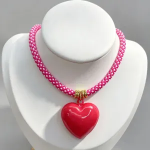 Pink braided rope necklace with glossy red heart pendant, stylish DIY fashion jewelry for women.