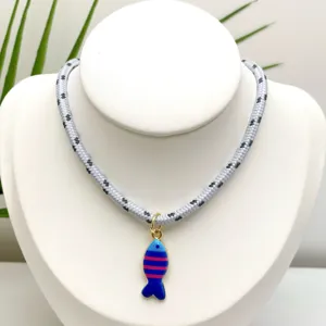 Vue détaillée du pendentif poisson coloré et rayé sur un collier en corde tressée.