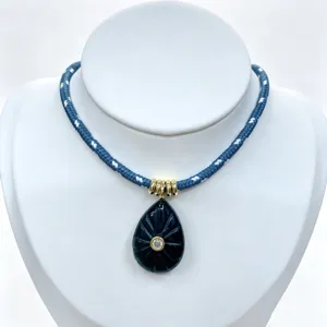 Blue braided rope necklace featuring a carved dark teardrop crystal pendant with sparkling stone.