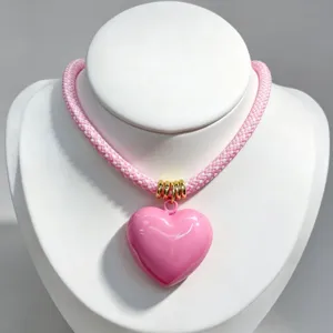 Pink woven rope statement necklace featuring glossy pink heart pendant fashion jewelry piece