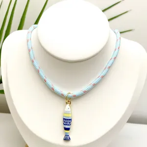 Vue détaillée du collier pendentif poisson rayé coloré de style marin avec corde tressée.