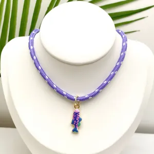 Vue détaillée du collier pendentif poisson émail style marin avec cordon tressé violet.