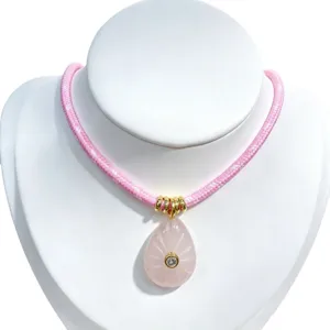 Exquisite pink crystal teardrop pendant necklace with braided cord and gold accents for women.
