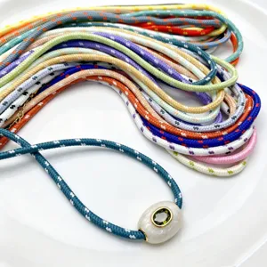 Detailaufnahme von bunten 3mm Polyesterkordeln mit Perlenanhänger für DIY Projekte.