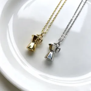 Gros plan détaillé des colliers pendentifs moka miniatures mignons en finition or et argent.
