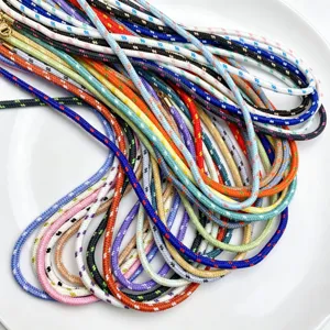 Detailansicht bunter gepunkteter Flechtkordeln fuer DIY Handarbeit und Schmuckherstellung.