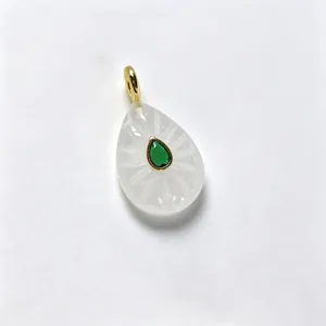 Exquisite teardrop carved white stone pendant featuring a central green gemstone and gold-tone bail.