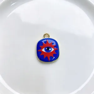 Close-up detail of a blue and red enamel sun eye metal pendant charm for DIY jewelry making.