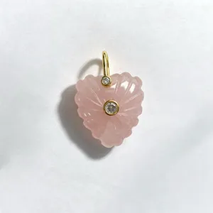 Exquisite carved pink crystal heart pendant detail, featuring gold-plated loop and stones.