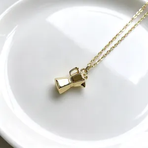 Collier pendentif cafetière moka dorée vue de détail, gros plan de bijoux charme café élégant.